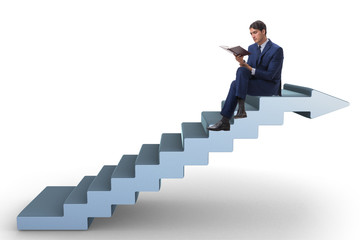 Businessman in career ladder concept reading book