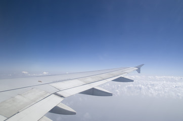 Airplane wing in the  cloudy sky