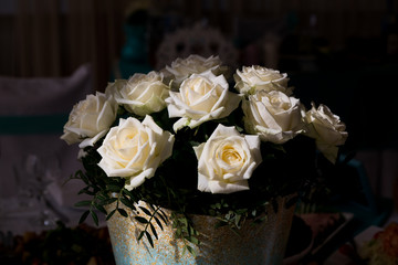 Decorative basket with white roses in the sun
