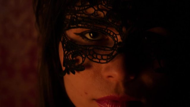 mysterious woman in a black, openwork mask