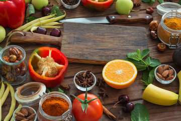 Healthy food, clean food selection:  fruits, vegetables, seeds, spices on brown boards with free space in the middle