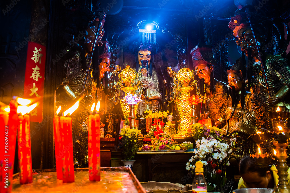 Wall mural statues and candles at mysterious jade emperor pagoda, ho chi minh city in vietnam