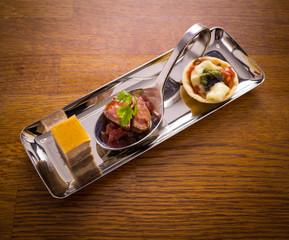 Canapés Served on Small Silver Platter With Silver Finger Spoon