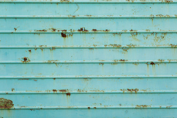 Texture of rusty sheet iron, green paint peeling off.