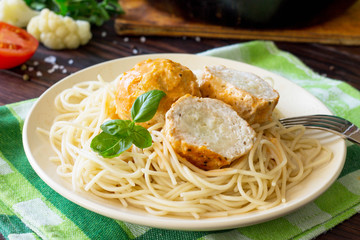 Thanksgiving Turkey dinner. Meat balls turkey with cauliflower in tomato sauce and spaghetti close-up on a wooden table.