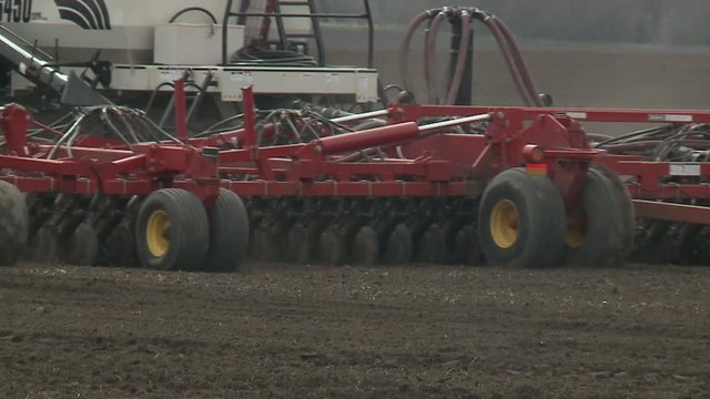 Tractor cultivating land in extreme close up  Tractor disc ground. Rural locality. The land is ready for planting grass.  Tractor handles field. Disking. The land is ready for planting