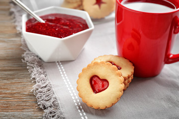 Traditional Christmas Linzer cookies with sweet jam on table