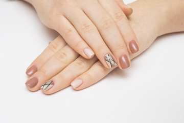 Fototapeta premium Hands with manicured nails covered with pink nail polish on fur background