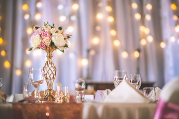 wedding table with exclusive floral arrangement prepared for reception, wedding or event centerpiece in rose gold colour
