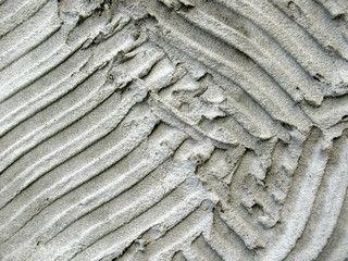 Fototapeta premium Gray plaster, putty, sand, wavy lines abstract texture background