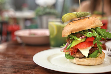 Plate with tasty fresh burger on table