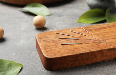 Board with needles for acupuncture on dark table