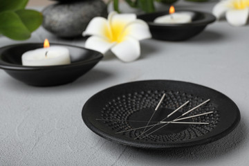 Plate with needles for acupuncture on table © New Africa