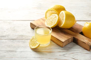 Photo sur Plexiglas Jus Verre avec jus de citron frais et fruits sur table