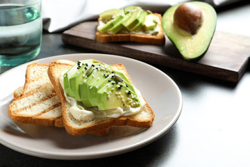 Toasted bread with avocado and seeds on table