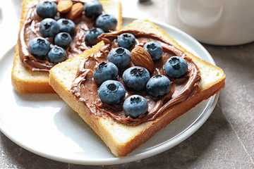 Toast bread with blueberries and chocolate paste on plate