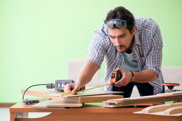 Naklejka na ściany i meble Woodworker working in his workshop