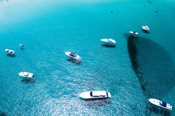 Aerial view of some yachts on an emerald and transparent Mediterranean sea. Gulf of the Great Pevero, Emerard coast, Sardinia, Italy.