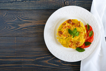 Tasty useful casserole from cauliflower on a plate on a dark wooden background. Top view. Vegetarian menu. Proper nutrition.