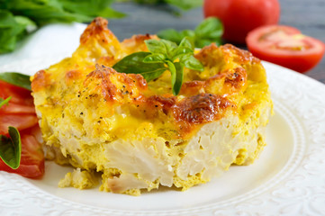 Tasty useful casserole from cauliflower on a plate on a dark wooden background. Vegetarian menu. Proper nutrition.