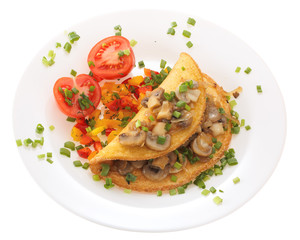 Omelet with mushrooms and tomatoes on a plate is decorated with onions. Isolated on white background.
