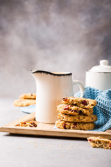 Oat meal cookies with raisins and cranberries on light gray background and blue napkin. Health breakfast or snack concept