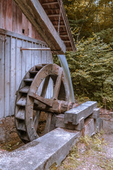 Alte Mühle antique wooden grain mill with large water wheel and flowing water with motion blur in the forest