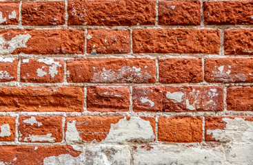 Background of orange bricks with different textures and spots of white paint