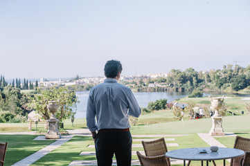 elegant man watching golf game next to the golf course