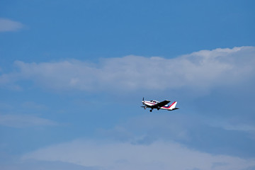 A plane in flight through blue and white skies.