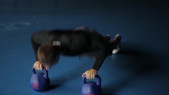 Man doing push-ups in gym, blue background.