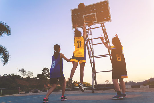 Girls playing basketball in park