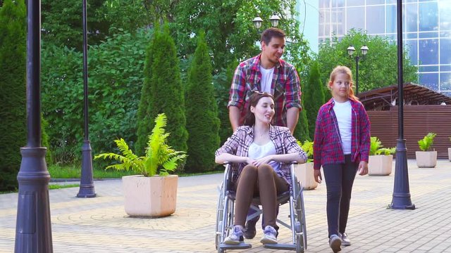 family on a walk, a woman with a disability in a wheelchair