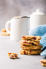 Oat meal cookies with raisins and cranberries on light gray background and blue napkin. Health breakfast or snack concept with copy space.