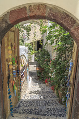 Street of Fira through entrance door in Santorini, Greece