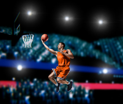 basketball player making slam dunk on basketball arena