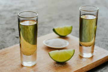 Tequila shot, mexican Alcoholic strong drinks and pieces of lime with salt in mexico