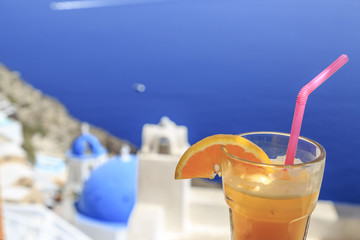 Orange juice with famous church of oia background in Oia, Santorini, Greece