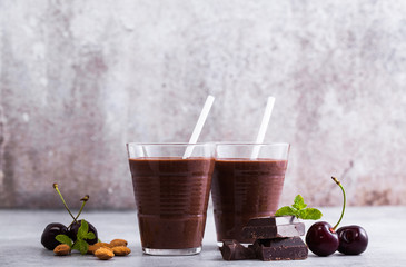 Chocolate smoothies with cherries and almonds. on a table of gray stone. Vegan protein drink for athletes and gourmets