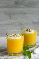 Peach dessert (mousse) with natural yoghurt, walnuts and mint in portion glasses