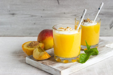 Peach dessert (mousse) with natural yoghurt, walnuts and mint in portion glasses