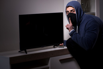 Burglar thief stealing tv from apartment house