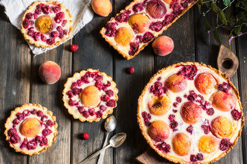 Rustic open pie with peach and raspberry, french galette . Peach tart. Raspberry tart. Tartalette with cream. Variety of bakery.