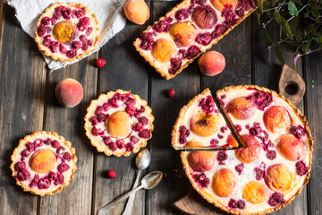 Fototapeta na wymiar Rustic open pie with peach and raspberry, french galette . Peach tart. Raspberry tart. Tartalette with cream. Variety of bakery.