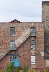 Obraz premium Old Brick Building with Smoke Stack