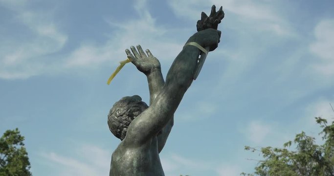 Statue with some yellow ties in its hands.