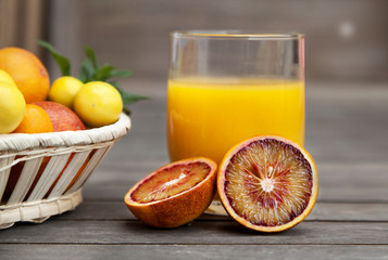 Citrus fruit and juice in a wooden background. Oranges, limes, Tangerines, Chinese oranges, blood...