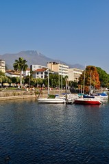 Fototapeta premium Port w mieście Locarno nad jeziorem Maggiore, jezioro w górach Ticino / Cardada w tle w południowej Szwajcarii