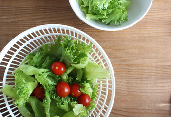 lettuce leaves and tomatoes hand on a wooden background