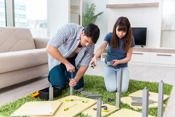 Young family assembling furniture at new house